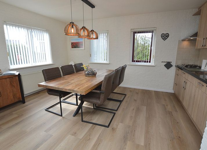 Gezellige woonkamer in Vakantiehuis Stappeland 205, De Koog, Texel met comfortabele banken en tuinzicht.