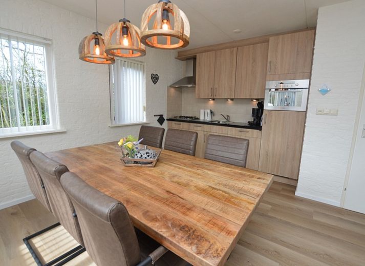 Gezellige woonkamer in Vakantiehuis Stappeland 205, De Koog, Texel met comfortabele banken en tuinzicht.