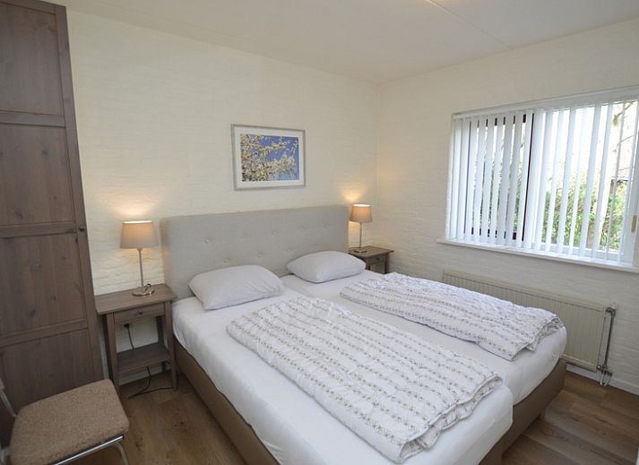 Gezellige woonkamer in Vakantiehuis Stappeland 205, De Koog, Texel met comfortabele banken en tuinzicht.