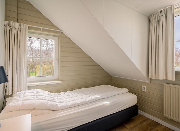 Stijlvolle zithoek in De Zandhaas, vakantiehuis in De Koog, Texel, met comfortabele banken en veel natuurlijk licht.