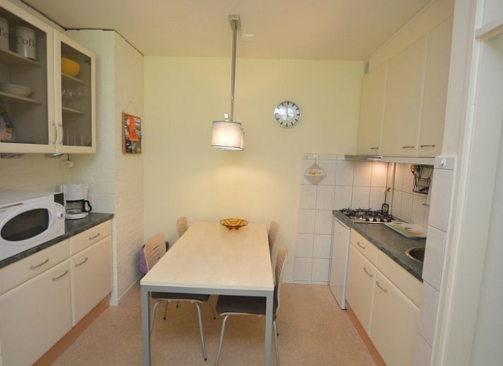 Lichte woonruimte in Appartement Kerckeland 64, De Koog, Texel met grote ramen en uitzicht op groen.