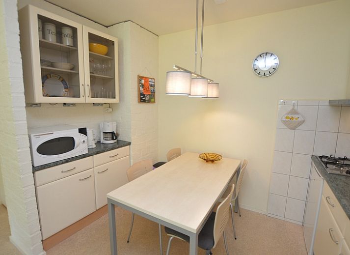 Lichte woonruimte in Appartement Kerckeland 64, De Koog, Texel met grote ramen en uitzicht op groen.