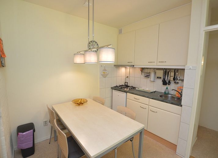 Lichte woonruimte in Appartement Kerckeland 64, De Koog, Texel met grote ramen en uitzicht op groen.