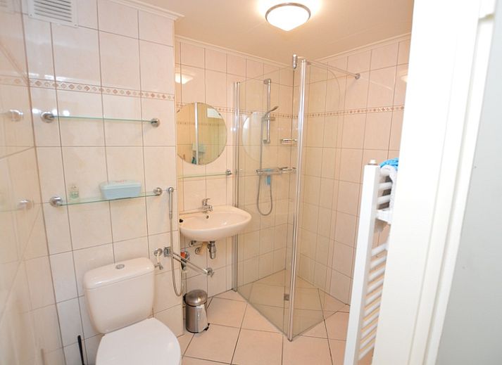 Lichte woonruimte in Appartement Kerckeland 64, De Koog, Texel met grote ramen en uitzicht op groen.