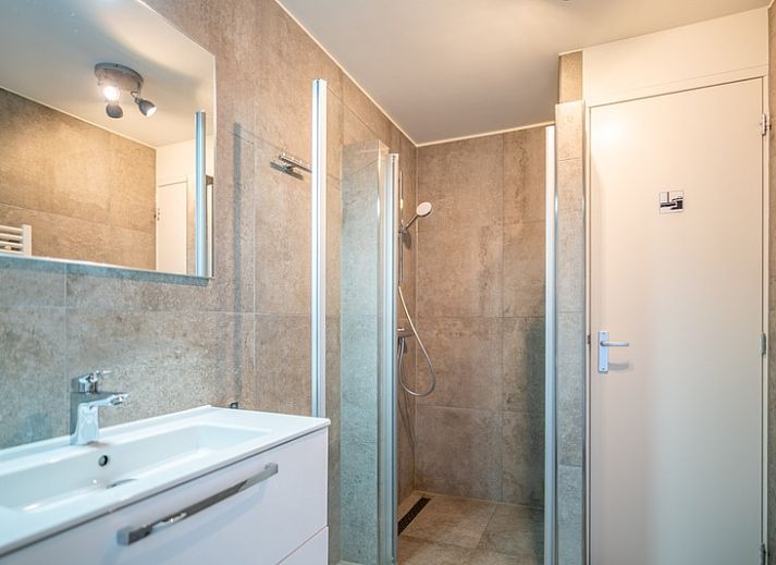 Stijlvolle zithoek in Appartement Juliana 156 Zeezicht, De Koog, Texel, met grote ramen en uitzicht op de Wadden.