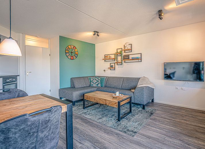 Gemuetliches Wohnzimmer im Appartement Zeedistel 20, De Koog, Texel mit moderner Kueche und bequemer Sitzecke.