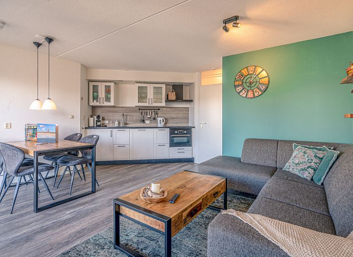 Gemuetliches Wohnzimmer im Appartement Zeedistel 20, De Koog, Texel mit moderner Kueche und bequemer Sitzecke.