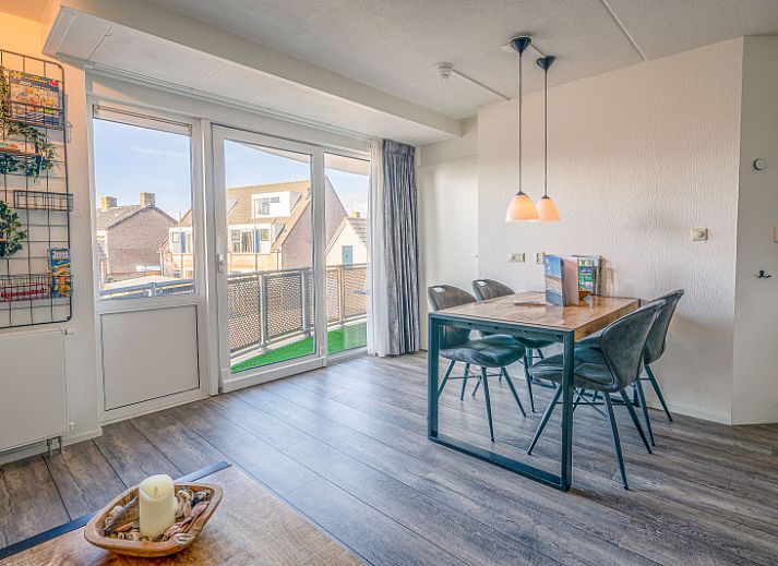 Gemuetliches Wohnzimmer im Appartement Zeedistel 20, De Koog, Texel mit moderner Kueche und bequemer Sitzecke.
