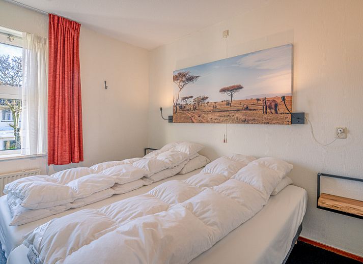 Stilvolle Einrichtung des Appartements Zeedistel 20, De Koog, Texel mit grossem Sofa und dekorativen Elementen.