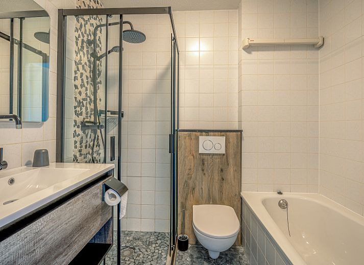 Stilvolle Einrichtung des Appartements Zeedistel 20, De Koog, Texel mit grossem Sofa und dekorativen Elementen.