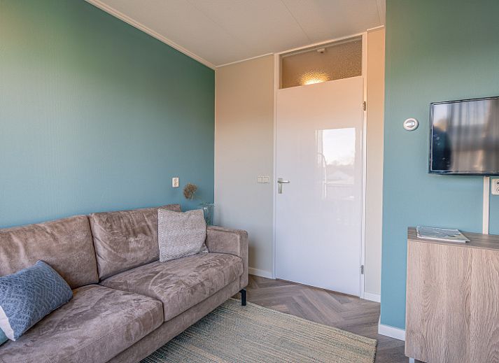 Gezellige woonkamer in Appartement Zeedistel 24, De Koog, Texel met uitzicht op het balkon.