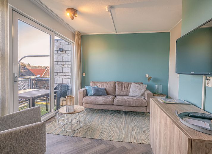 Gezellige woonkamer in Appartement Zeedistel 24, De Koog, Texel met uitzicht op het balkon.