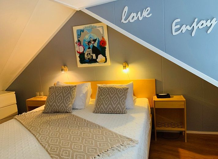 Gezellige woonkamer van vakantiehuis Texel A in De Koog, Texel, met comfortabele zithoek en openslaande deuren naar het terras.