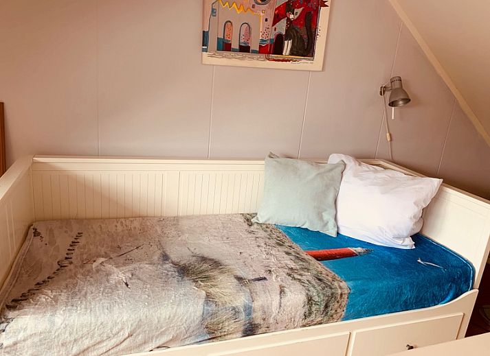 Gezellige woonkamer van vakantiehuis Texel A in De Koog, Texel, met comfortabele zithoek en openslaande deuren naar het terras.