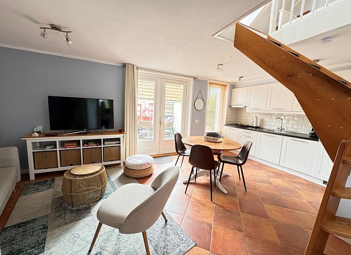Gezellige woonkamer van vakantiehuis Texel A in De Koog, Texel, met comfortabele zithoek en openslaande deuren naar het terras.