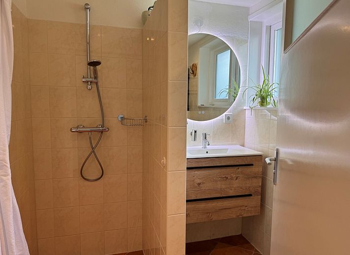 Gezellige woonkamer van vakantiehuis Texel A in De Koog, Texel, met comfortabele zithoek en openslaande deuren naar het terras.