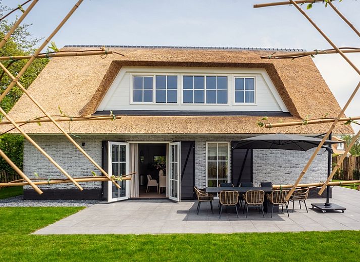 Villa 25a in De Koog, Texel met rieten dak en ruime tuin, ideaal vakantiehuis op de Waddeneilanden.