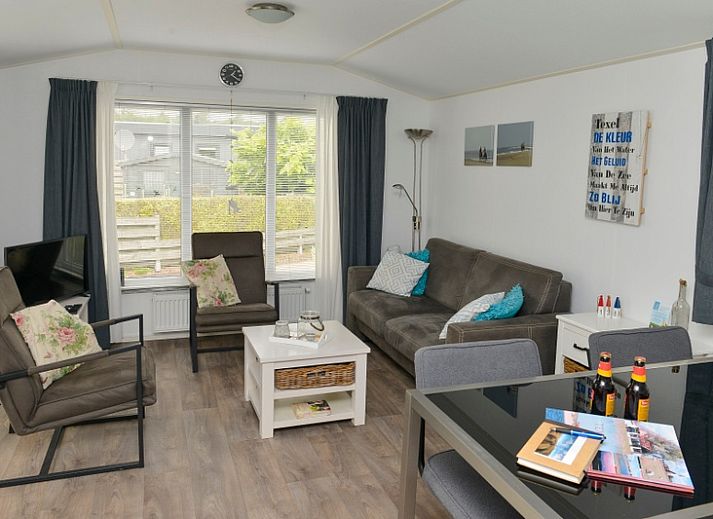 Chalet Bregkoog 138 'Sinne' in De Koog, Texel biedt een ruim terras met loungebank en bloeiende planten.