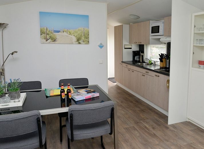 Chalet Bregkoog 138 'Sinne' in De Koog, Texel biedt een ruim terras met loungebank en bloeiende planten.