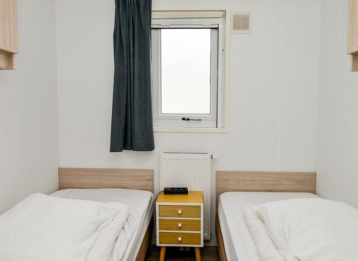 Chalet Bregkoog 138 'Sinne' in De Koog, Texel biedt een ruim terras met loungebank en bloeiende planten.