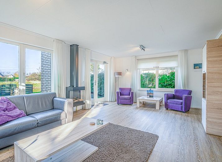 Sonnige Terrasse am Ferienhaus Honeysuckle 59 in De Koog, Texel mit bequemen Sitzgelegenheiten im Freien.