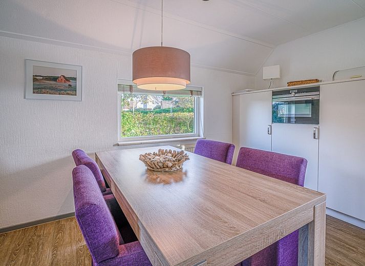 Sonnige Terrasse am Ferienhaus Honeysuckle 59 in De Koog, Texel mit bequemen Sitzgelegenheiten im Freien.