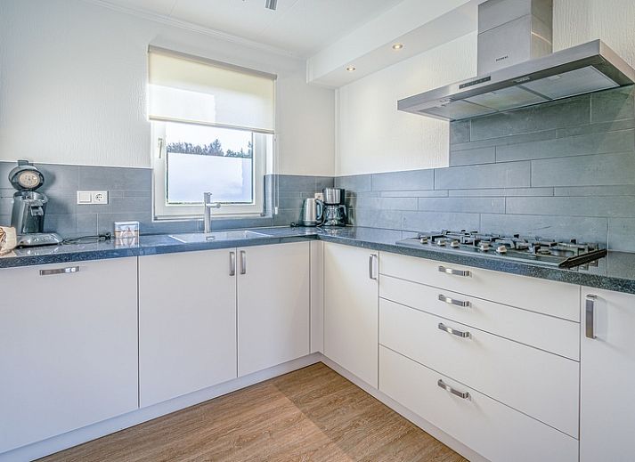 Sonnige Terrasse am Ferienhaus Honeysuckle 59 in De Koog, Texel mit bequemen Sitzgelegenheiten im Freien.