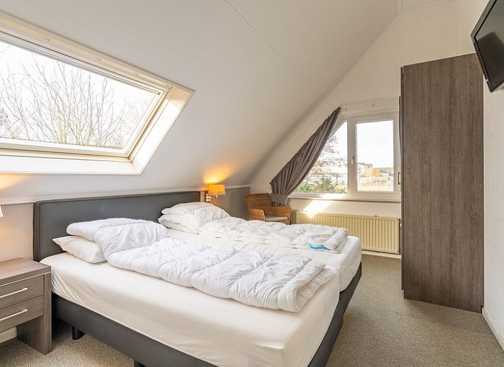 Sonnige Terrasse am Ferienhaus Honeysuckle 59 in De Koog, Texel mit bequemen Sitzgelegenheiten im Freien.