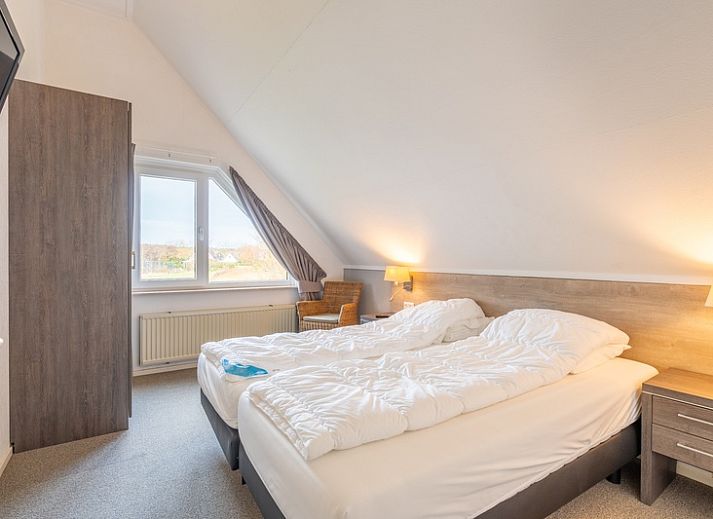 Sonnige Terrasse am Ferienhaus Honeysuckle 59 in De Koog, Texel mit bequemen Sitzgelegenheiten im Freien.