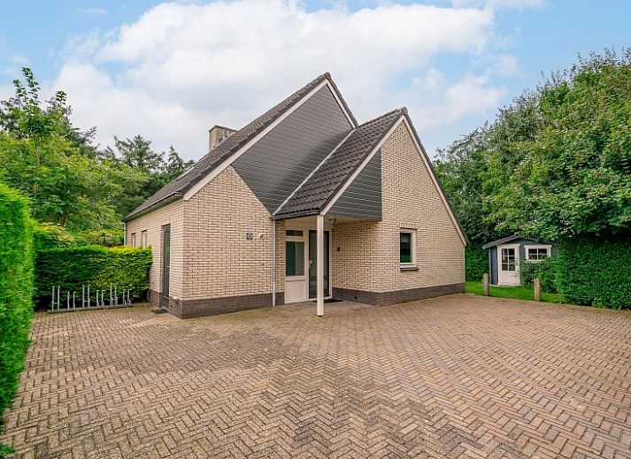Terras van Vakantiehuis Kamperfoelie 31 in De Koog, Texel met tuinmeubilair en groene omgeving.