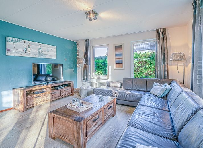 Terras van Vakantiehuis Kamperfoelie 31 in De Koog, Texel met tuinmeubilair en groene omgeving.