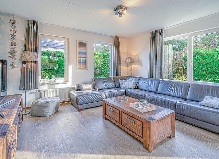 Terras van Vakantiehuis Kamperfoelie 31 in De Koog, Texel met tuinmeubilair en groene omgeving.