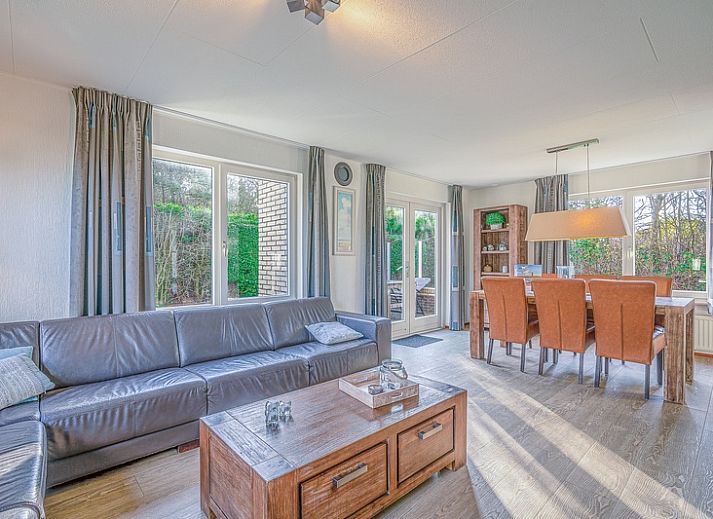 Terras van Vakantiehuis Kamperfoelie 31 in De Koog, Texel met tuinmeubilair en groene omgeving.