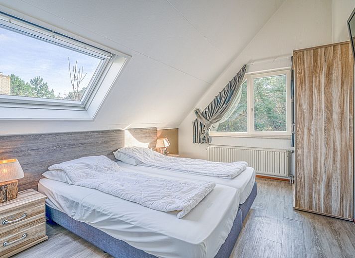 Vooraanzicht van Vakantiehuis Kamperfoelie 31 in De Koog, Texel met ruime oprit en omringende natuur.