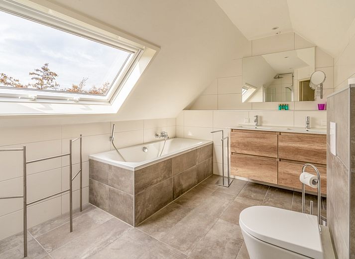 Gezellige woonkamer van Vakantiehuis Kamperfoelie 65, De Koog, Texel met comfortabele banken en veel lichtinval.