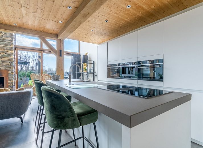 Gemuetliches Wohnzimmer der Villa 183 mit Whirlpool in De Koog Texel, mit grossen Fenstern und Kamin.