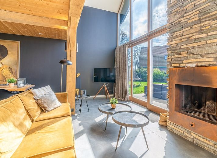 Bright living room of Villa 181 with Hot tub in De Koog, Texel with fireplace and views of the Wadden Islands green garden.