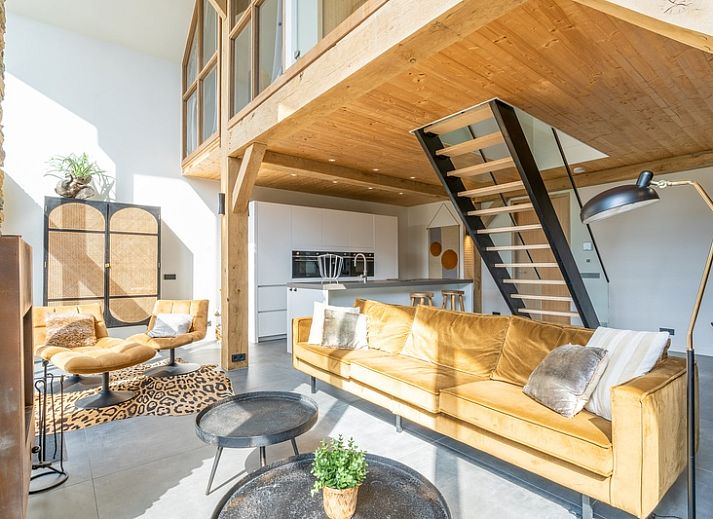 Bright living room of Villa 181 with Hot tub in De Koog, Texel with fireplace and views of the Wadden Islands green garden.