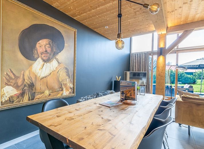 Bright living room of Villa 181 with Hot tub in De Koog, Texel with fireplace and views of the Wadden Islands green garden.