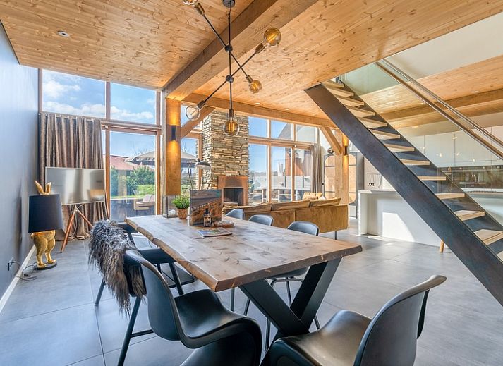 Bright living room of Villa 181 with Hot tub in De Koog, Texel with fireplace and views of the Wadden Islands green garden.
