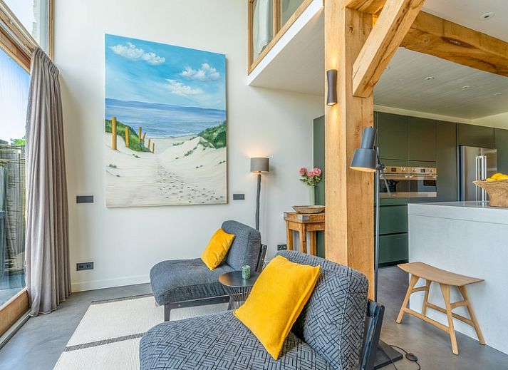 Gezellige woonkamer van Villa 193, De Koog, Texel, met open haard en uitzicht op natuur.