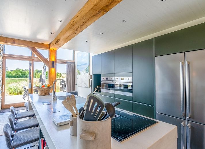 Gezellige woonkamer van Villa 193, De Koog, Texel, met open haard en uitzicht op natuur.