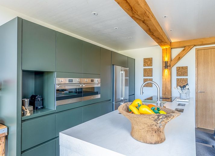 Gezellige woonkamer van Villa 193, De Koog, Texel, met open haard en uitzicht op natuur.