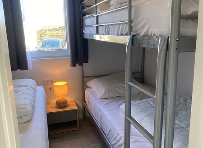 Gemuetliches Wohnzimmer im Chalet Bregkoog 94, De Koog, Texel. Bequemes Sofa und stilvolle Einrichtung fuer einen entspannten Aufenthalt.