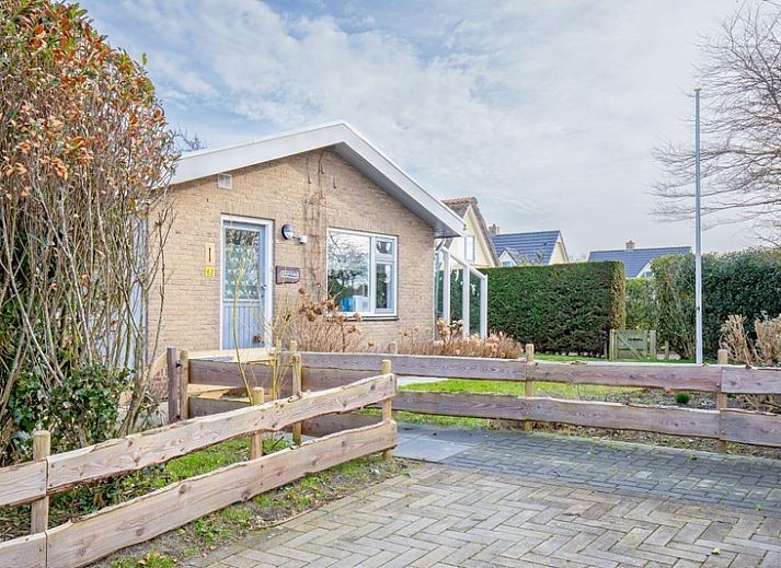 Terras met zonnescherm bij De Schutstal vakantiehuis in De Koog, Texel
