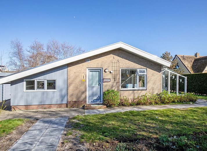 Terras met zonnescherm bij De Schutstal vakantiehuis in De Koog, Texel