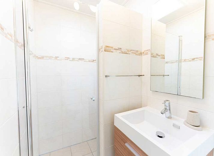 Lichte woonkamer van De Koperwiek in De Koog Texel met uitzicht op natuur.