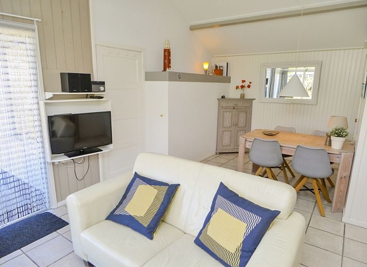 Gemuetliches Wohnzimmer des Ferienhauses Achter de Brem, De Koog, Texel mit Blick auf die Natur.