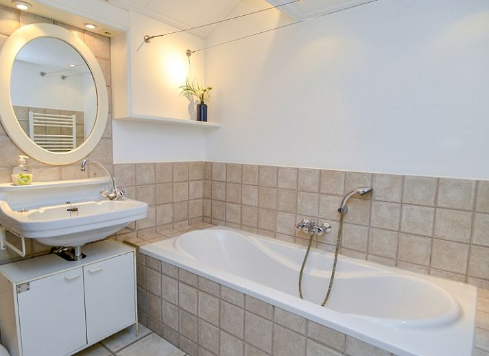 Gemuetliches Wohnzimmer des Ferienhauses Achter de Brem, De Koog, Texel mit Blick auf die Natur.