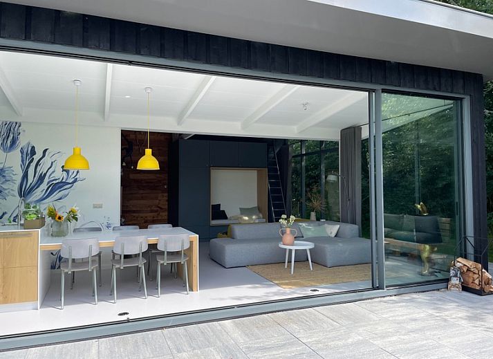 Geraeumige Terrasse im Ferienhaus De Koerie in De Koog, Texel, umgeben von gruener Natur.